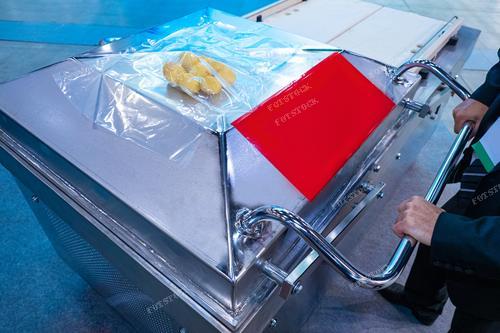На снимке изображена упаковка продуктов в вакуумные пакеты с использованием специального оборудования. Этот процесс иллюстрирует сферу пищевой промышленности, где создаются удобные условия хранения для продуктов. Фотография вызывает ассоциации с технологическим процессом, олицетворяя современные методы упаковки и производства продуктов.